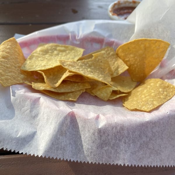 A basket of crispy tortilla chips with a side of salsa at Castañedas Mexican Restaurant.