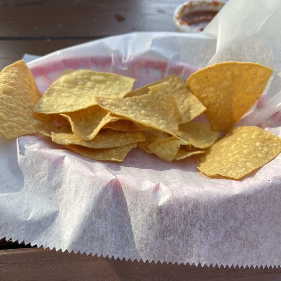 A basket of crispy tortilla chips with a side of salsa at Castañedas Mexican Restaurant.