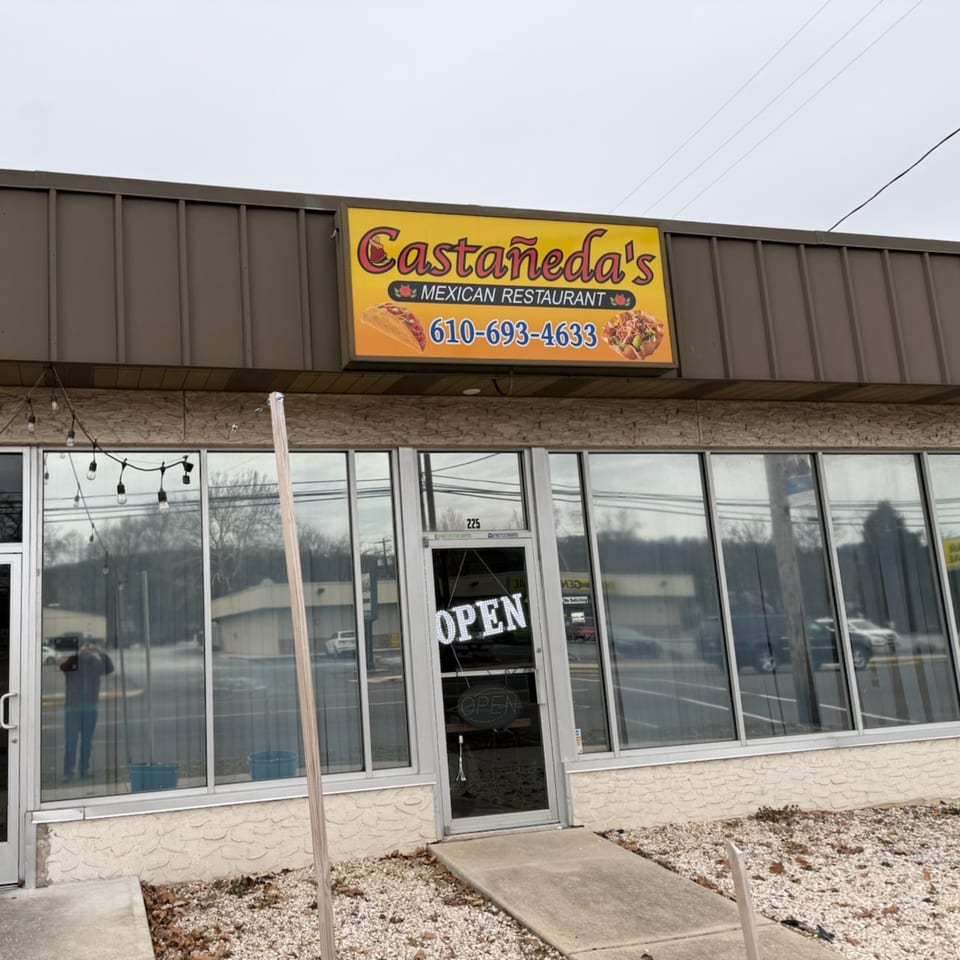 Exterior of Castañeda's Mexican Restaurant with a bright yellow sign and "OPEN" on the door.