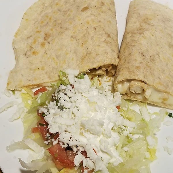Two Castañedas Mexican Restaurant quesadillas with melted cheese and chicken, served with lettuce, tomatoes, and cotija cheese.